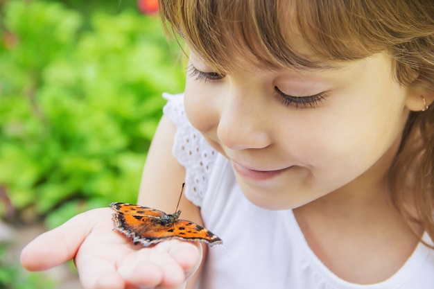 Enfant avec un papillon. Idée leuconoe. Mise au point sélective.