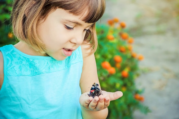 Enfant avec un papillon. Mise au point sélective. la nature.