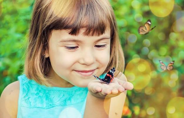 Enfant avec un papillon. Mise au point sélective. la nature.