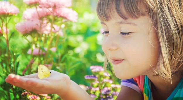 Enfant avec un papillon. Mise au point sélective. la nature.