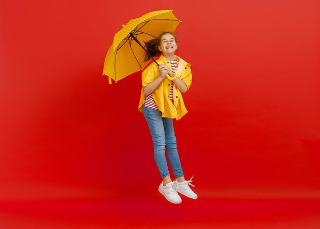 Enfant avec parapluie sur fond coloré