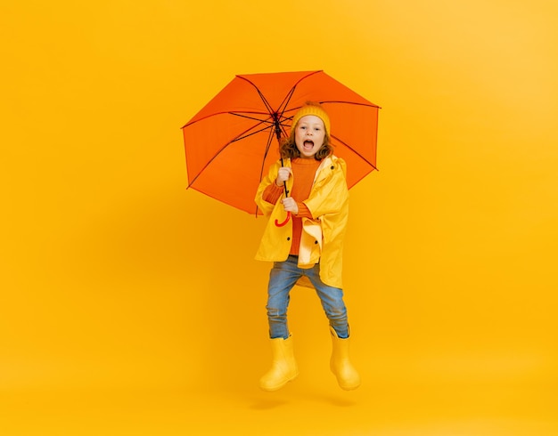 Enfant avec parapluie sur fond coloré