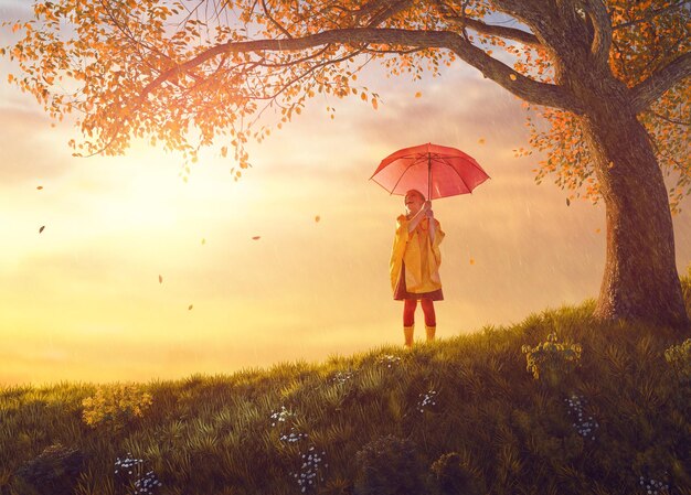 Enfant avec un parapluie rouge