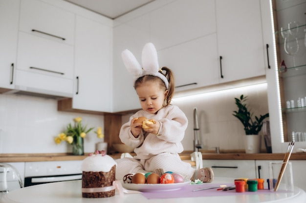 Enfant peint des oeufs de pâques Créativité avec les mains des enfants avec des oeufs sur le fond d'une table avec des peintures