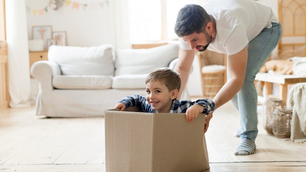 Enfant et père jouant avec une boîte