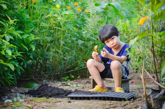 enfant plantant des légumes dans un bac