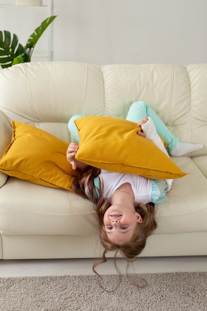 Enfant Avec Un Plâtre Sur Un Poignet Ou Un Bras Cassé Souriant Et S'amusant Sur Un Canapé