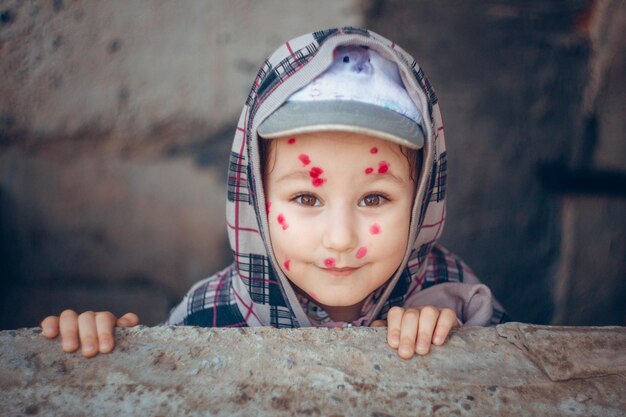 Un enfant avec des points rouges sur son visage