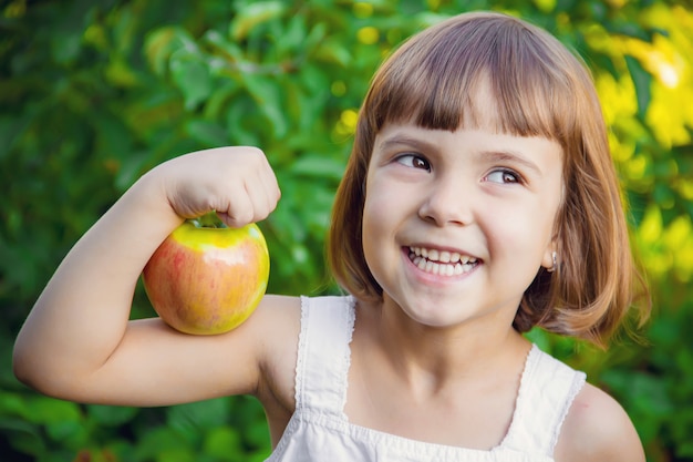 Enfant avec une pomme. Mise au point sélective. la nature