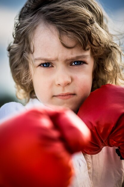 Enfant portant des gants de boxe rouges