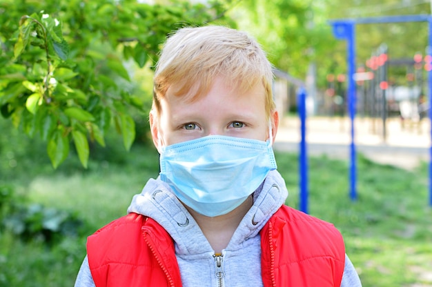 Photo enfant portant un masque dans le parc. masque facial pour la protection contre l'épidémie de coronavirus. épidémie de coronavirus