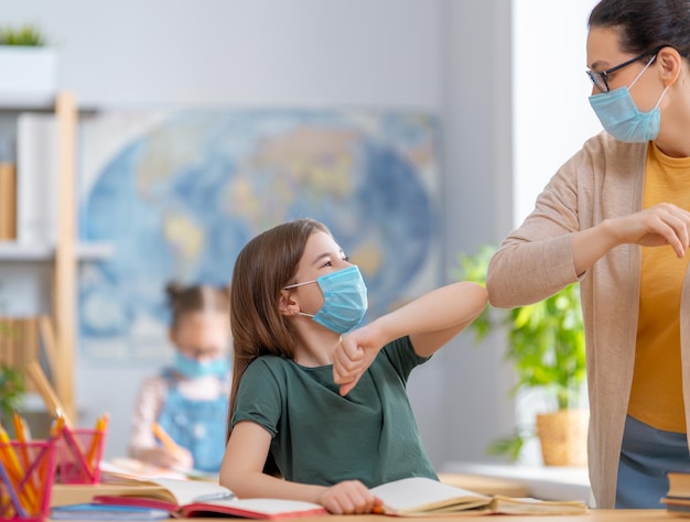 Enfant portant un masque facial apprenant en classe