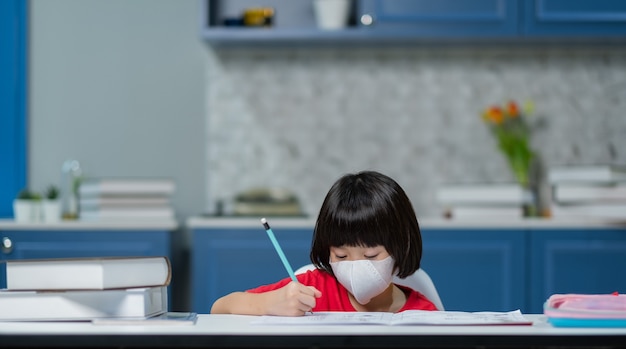 enfant portant un masque de protection et faire ses devoirs, papier à écrire pour enfants, concept d'éducation