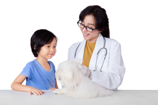 Un enfant porte son chien chez le vétérinaire.