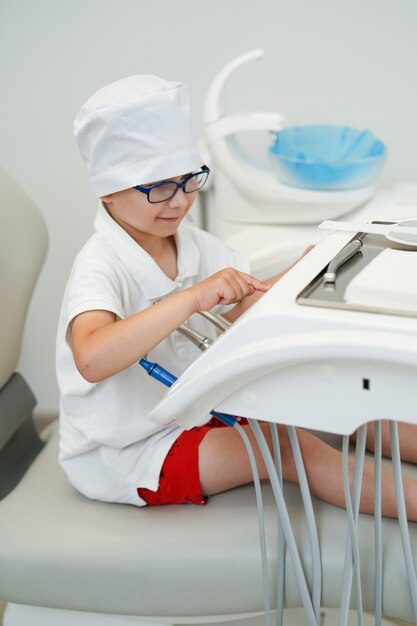 L'enfant porte un uniforme médical en jouant. Joyeux petit garçon drôle portant l'uniforme.