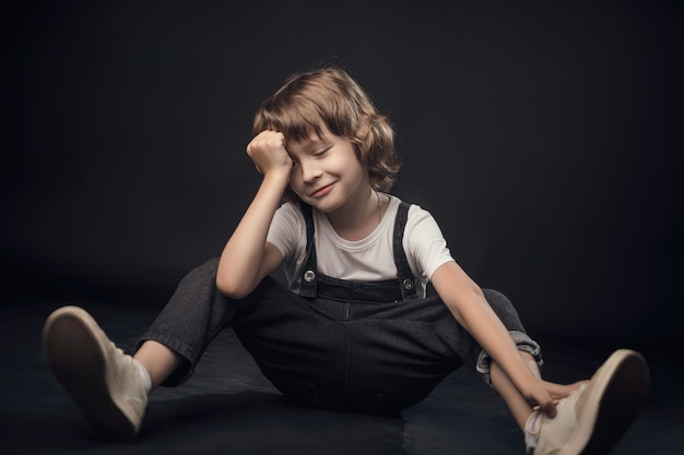 Enfant posant émotionnellement à la caméra dans le Studio sur fond blanc