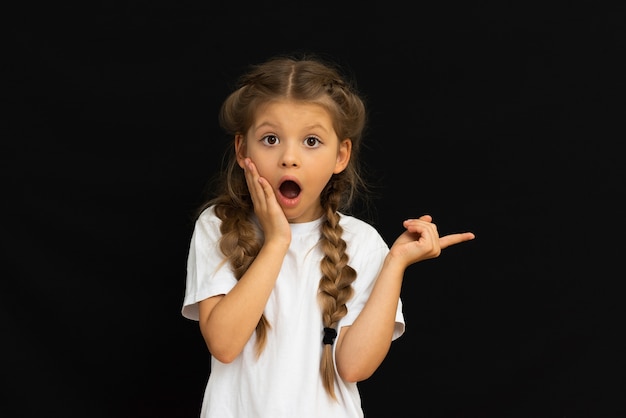 Un enfant pose sur un fond noir.