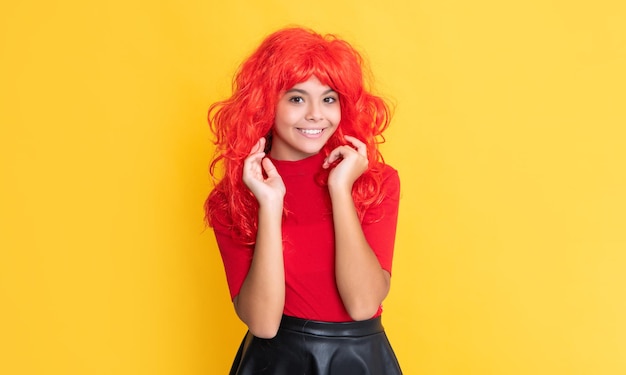 Enfant positif aux cheveux longs rouges sur fond jaune