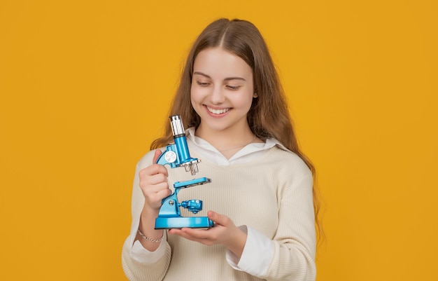 Enfant positif avec microscope sur fond jaune