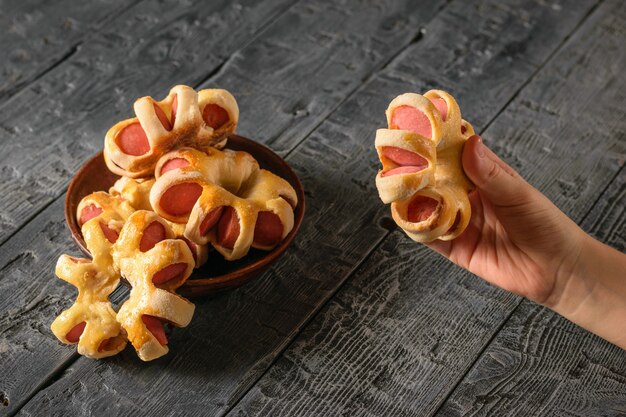 L&#39;enfant prend une main saucisse maison dans la pâte du bol.