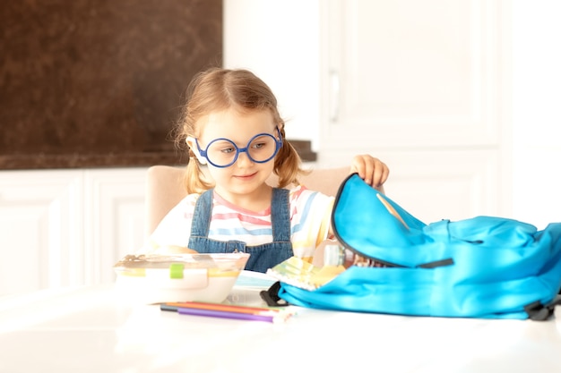 Enfant préparant le sac à dos pour l'école le matin ensoleillé