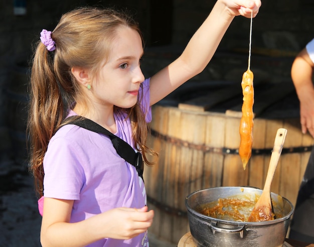 un enfant prépare un dessert géorgien traditionnel churchkhela