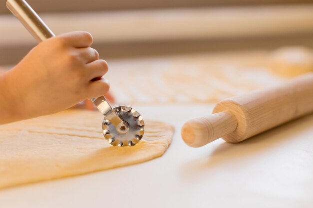 Un enfant prépare des pâtes maison dans la cuisine