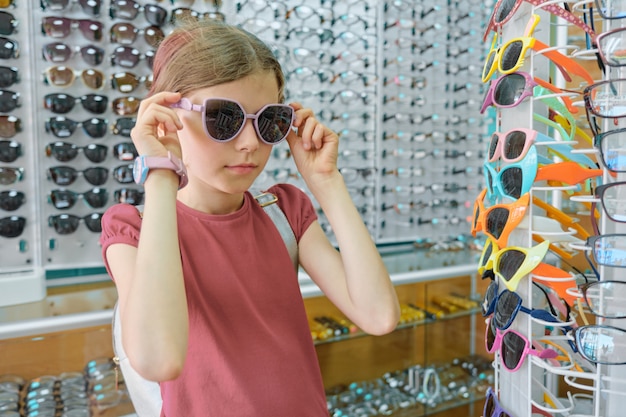 Enfant près de vitrine en magasin de lunettes