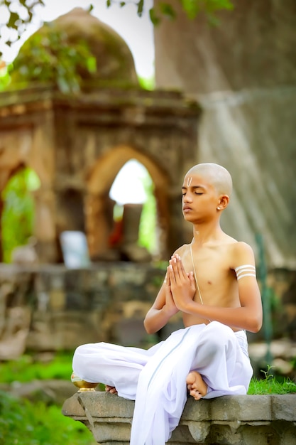 Enfant prêtre indien faisant du yoga au parc