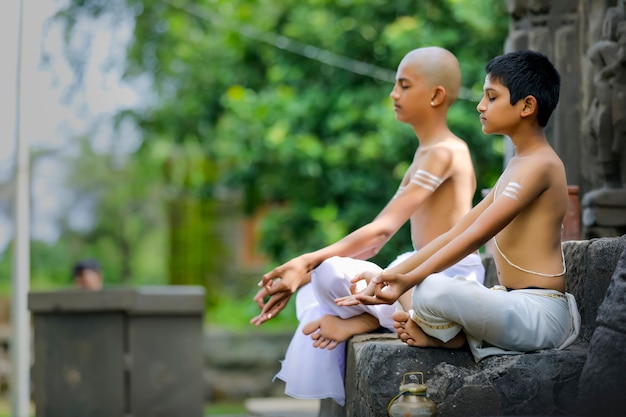 Enfant prêtre indien faisant du yoga au parc