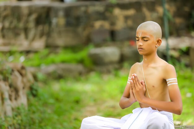 L'enfant prêtre indien faisant la méditation