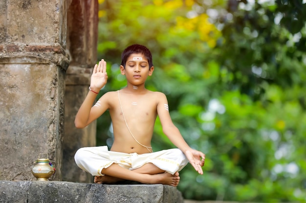 L'enfant prêtre indien faisant la méditation