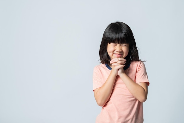 L'enfant prie, les mains jointes en prière