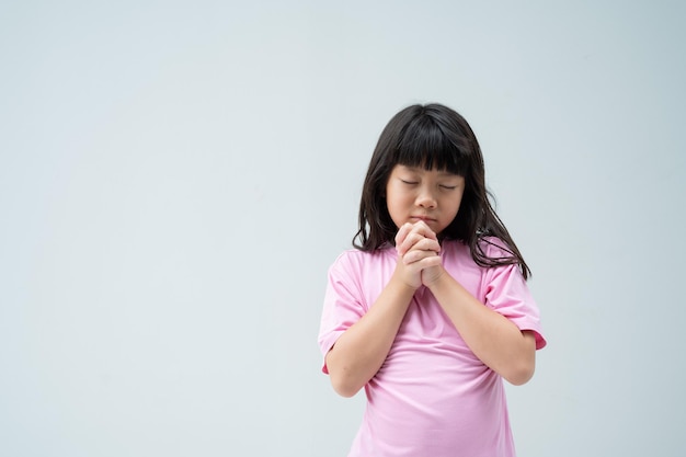 L'enfant prie les mains jointes en prière