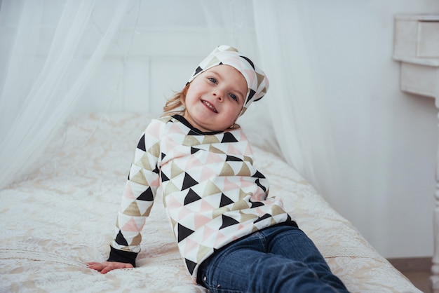 Enfant en pyjama chaud et doux jouant au lit