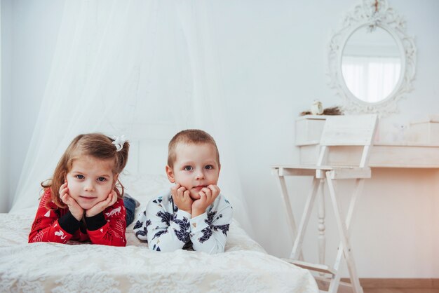 Enfant en pyjama chaud et doux jouant au lit