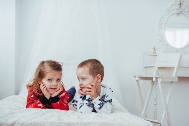 Enfant en pyjama chaud et doux jouant au lit