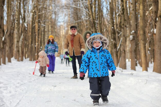 Enfant qui court dans un parc d'hiver et s'amuse en famille