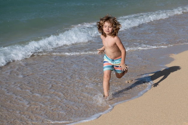 Enfant qui court sur la plage Un enfant heureux qui court en mer pendant les vacances d'été, voyage et aventure sur la mer ou l'océan