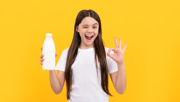 Un enfant qui fait un clin d'œil tient une boisson laitière adolescente qui va boire du lait