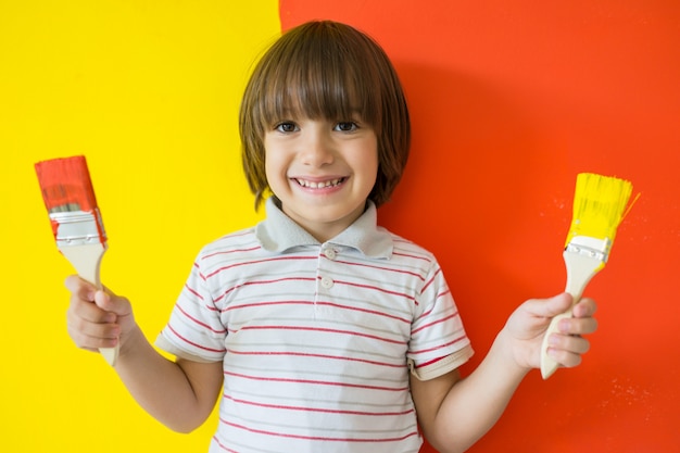 Enfant qui peint le mur de la maison en couleurs