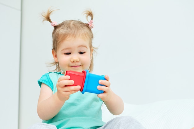 Enfant de race blanche jouant avec des jouets colorés à la maison