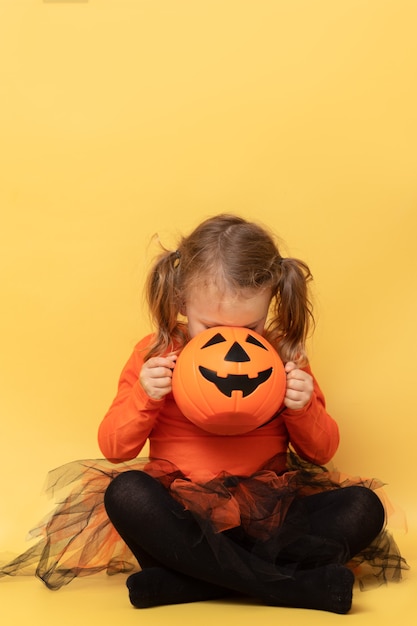 Enfant à la recherche de bonbons en pot citrouille halloween vertical jaune isolé