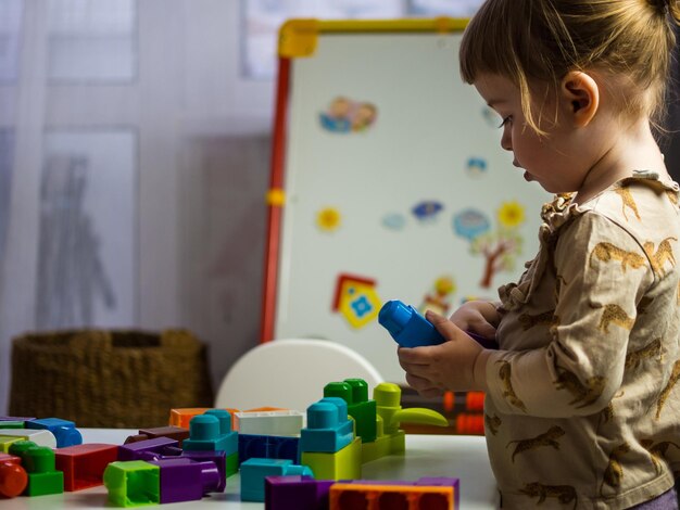 Photo l'enfant récupère le designer à table dans la chambre des enfants