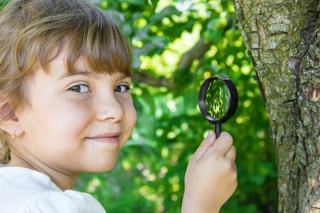 L&#39;enfant regarde à la loupe. Augmenter. mise au point sélective.