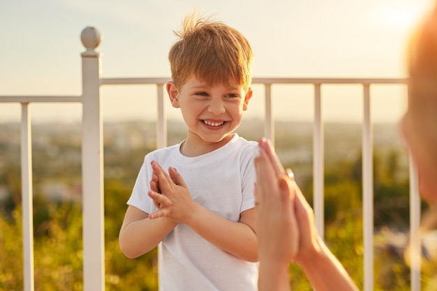 Enfant riant avec la mère frappant des mains