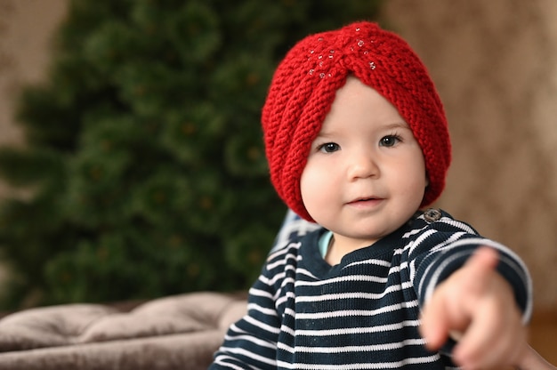 L'enfant rit et montre un doigt. L'enfant a 0-1 ans. un petit enfant montre un doigt d'une main. portrait d'enfant d'un an.