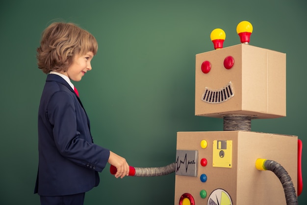 Enfant avec robot jouet à l'école. Concept de technologie de réussite et d'innovation