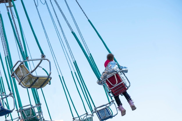 Enfant S'amusant à Cheval Sur Un Carrousel à Chaînes Dans Le Parc D'attractions B