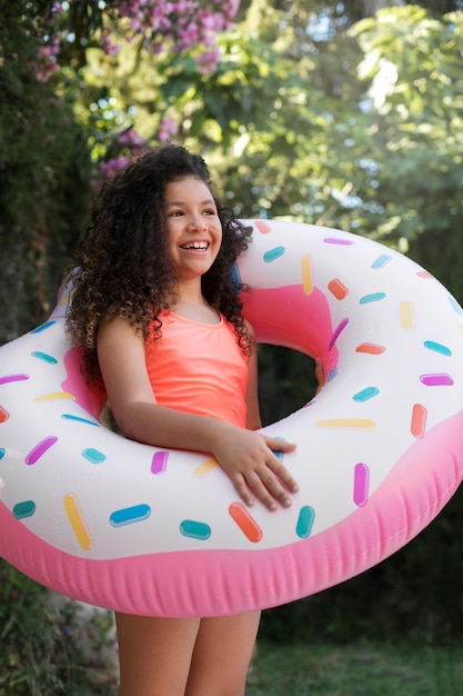 Enfant s'amusant avec flotteur au bord de la piscine